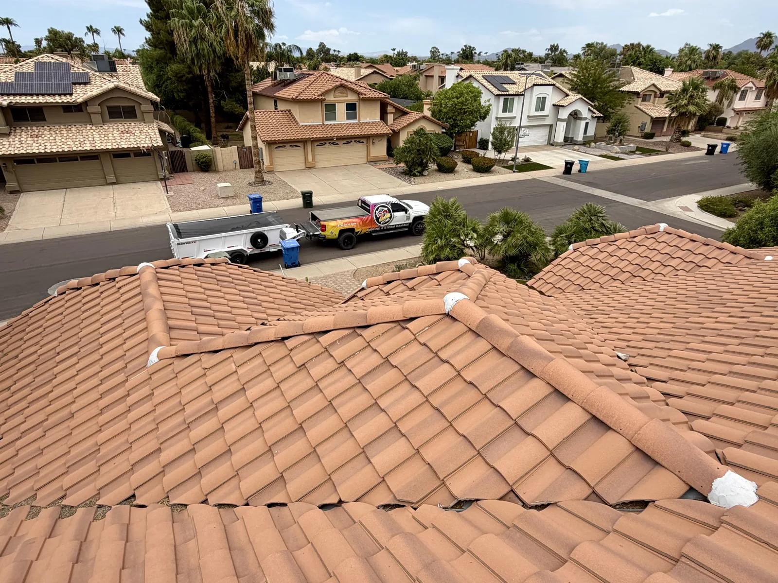 Tile roof overlooking a neighborhood with a 22 Home Roofing truck nearby